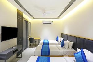 新德里Hotel Apple Villa - Near Delhi Airport with Free Airport Transsfer的酒店客房设有两张床和一台平面电视。