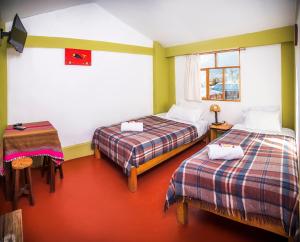 YanqueSumaq Wayra的客房设有两张床、一张桌子和一扇窗户。