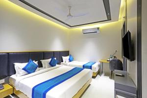 新德里Hotel Apple Villa - Near Delhi Airport with Free Airport Transsfer的酒店客房设有两张床和电视。