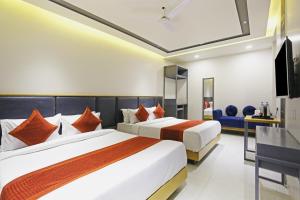 新德里Hotel Apple Villa - Near Delhi Airport with Free Airport Transsfer的酒店客房设有两张床和电视。