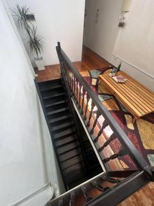 马六甲SPOT ON 90898 Kasturi Alley Guest House & Cat Hotel的楼梯,配有木凳和木桌