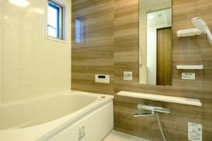 东京Home n Lounge的带浴缸和镜子的浴室