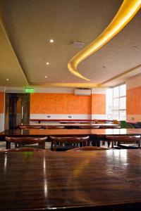 麦克坦Cebu Dulcinea Hotel and Suites-MACTAN AIRPORT HOTEL的空房间,配有木桌和长凳