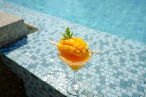 芭东海滩Holiday Inn Express Phuket Patong Beach Central, an IHG Hotel的 ⁇ 萝鸡尾酒,在泳池旁的葡萄酒杯中