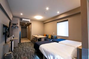 东京Minn Akihabara的酒店客房设有两张床和一张桌子。