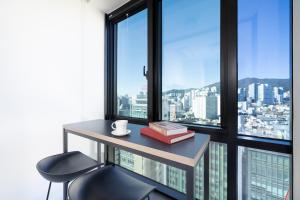 釜山From H Reposant Hotel Busnan Seomyeon的窗户间配有一张桌子和一把椅子