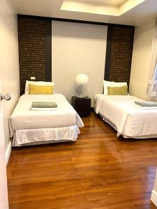 攀瓦海滩Bel Air Cape Panwa Resort Phuket的配有2张床的木地板客房