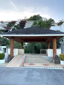 攀瓦海滩Bel Air Cape Panwa Resort Phuket的停车场内一个带黑色屋顶的亭子