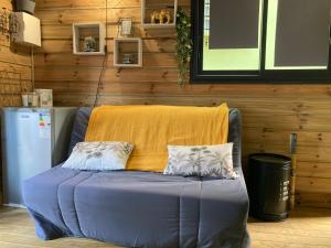 拉波塞雄Tiny house bois cosy « Halte là »的一张蓝色的沙发,上面有两个枕头