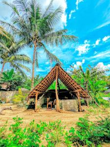 达瓦拉维Maika safari lodge的一座小小屋,后面有棕榈树