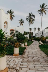 普瓦尼梅查恩加尼LUX Marijani Zanzibar的棕榈树建筑前的石路