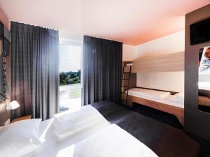 德绍B&B Hotel Dessau的酒店客房设有两张床和窗户。