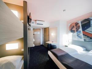 德绍B&B Hotel Dessau的酒店客房配有两张床和一张书桌