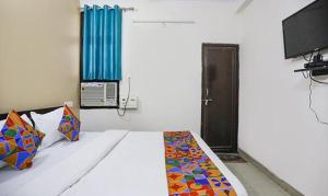 KakarmathaFabHotel Lily Grand的一间卧室配有一张床和一台电视