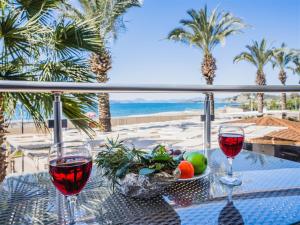费特希耶阿瓜日落海滩出租度假酒店的桌子上放两杯葡萄酒,享有海滩美景