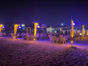 巴加Yellow Sky的一群桌子和椅子在晚上在海滩上
