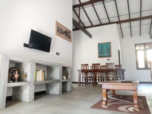 希克杜沃Villa Conch by Om - Private House - Hikkaduwa的客厅配有桌子和电视