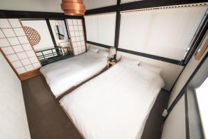 金泽HISORI Arts and Stay的小型客房设有2张床和窗户。