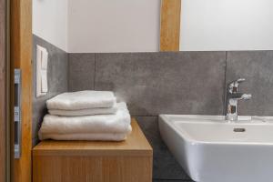 纽科琴格罗斯夫纳撤多夫奥贝昆雷度假屋的浴室设有水槽和一堆毛巾