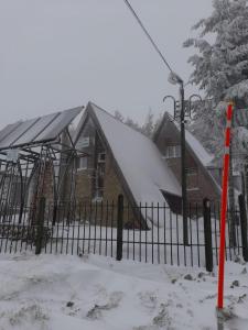 沃利乌格乡Vilele Birta的一座带围栏的雪盖屋顶的房子