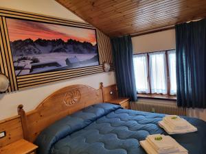 上福尔尼Albergo Meuble Tarandan的卧室配有一张床,墙上挂有绘画作品