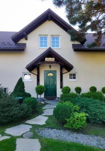 什切尔克Molonówka Guest House的一座带绿门和走道的房子