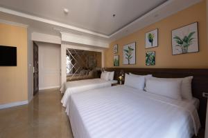 河内Nature Hotel的一间卧室配有两张床和电视