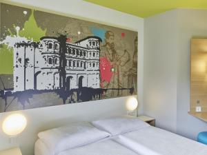 特里尔特里尔住宿加早餐酒店的卧室,墙上挂着一幅画,位于床上方