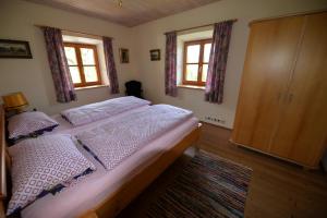 里姆斯廷格Ferienwohnung Kurz的一间卧室设有一张床和两个窗户。