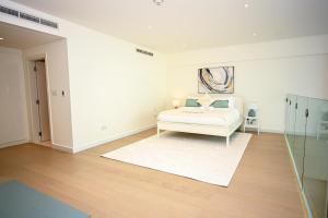 阿布扎比1BR Loft Soul Beach Escape - Mamsha Al Saadiyat的白色的客房配有床和镜子