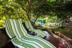 波尔Holiday Home ART - Bol的两只绿白长椅,坐在树下