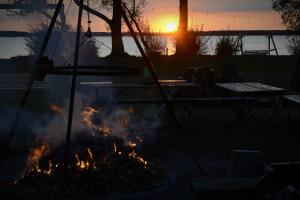 什切齐内克Camping Szczecinek Domy Wypoczynkowe的火坑,背景是日落