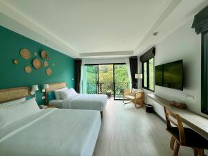 奥南海滩Keereen Resort - Ao Nang Krabi的酒店客房设有两张床和电视。