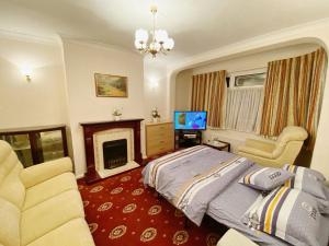 伦敦Barking London House sleeps 11 - parking - train tube - airport的一间卧室配有一张床、一个壁炉和一台电视。