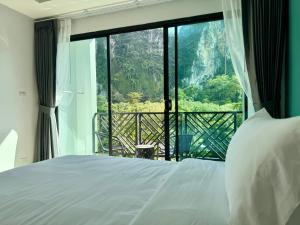 奥南海滩Keereen Resort - Ao Nang Krabi的一间卧室设有一张床和一个大窗户