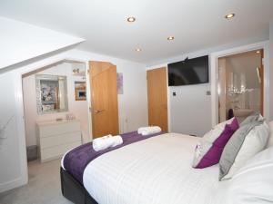 Luxulyan1 Bed in Charlestown 53680的卧室配有一张带紫色枕头的大型白色床。