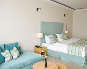 蒂门多弗施特兰德SeeHuus Lifestyle Hotel的一间带两张床和一张沙发的客厅