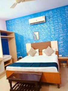斋浦尔Hotel Braj Haveli的一间卧室配有一张蓝色墙壁的床