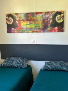 SERRA DI FIUMORBOles bungalows de Lisa Maria的一间卧室设有两张床,墙上挂着一幅画