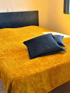 SERRA DI FIUMORBOles bungalows de Lisa Maria的一张黄色的床,上面有蓝色的枕头