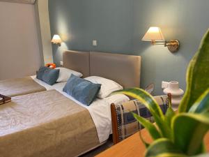 海若克利欧格列柯酒店 的一间卧室设有两张床和盆栽植物