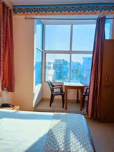 斋浦尔Hotel Braj Haveli的卧室设有窗户和桌椅
