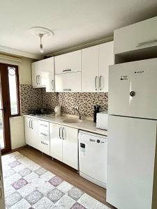 亚洛瓦Halic Apart Hotel的厨房配有白色橱柜和白色冰箱。