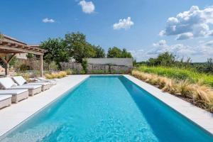 RadovaniVilla Charlotte for 14 persons with 73m2 Pool in Central Istria - Daily Housekeeping & Breakfast Service的后院的蓝色海水游泳池