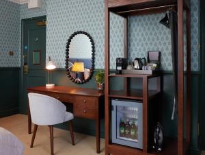 贝里圣埃德蒙兹Dog and Partridge by Greene King Inns的客房设有书桌、镜子和椅子。