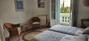 耶尔Villa Marguerite的客房设有床、椅子和窗户。