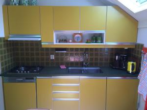 尤菲蒂祖斯恩佐公寓的厨房配有黄色橱柜和水槽