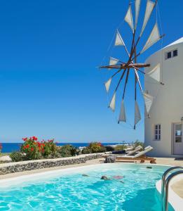 易莫洛林风车别墅酒店的一座带遮阳伞的游泳池,