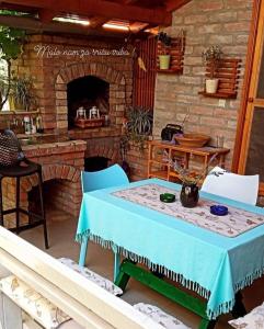 武科瓦尔Kuća za odmor Mirni kutak Vukovar的砖砌壁炉前的桌椅