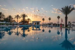 凯麦尔Mirage Park Resort-Ultra All Incl.的棕榈树泳池和日落背景